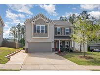 Two-story home with gray siding, brick accents, an attached two-car garage, and a manicured front lawn at 528 Holden Forest Dr, Youngsville, NC 27596