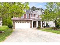 Charming two-story home featuring a stone facade, red shutters, and a spacious driveway at 609 Conover Rd, Durham, NC 27703
