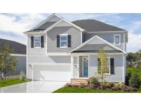 Charming two-story home featuring a two-car garage and a welcoming blue front door at 900 Emmer St, Rolesville, NC 27571