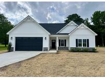 Charming single-story home featuring black garage door, black shutters, black front door and manicured front lawn at 1008 Peedin Rd, Selma, NC 27576