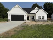 Charming new construction home with a black garage door and stone accents at 1008 Peedin Rd, Selma, NC 27576