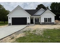 Beautiful new construction home with black garage door and stone veneer details at 1008 Peedin Rd, Selma, NC 27576