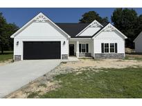 Charming new construction home with a dark garage door, stone accents, and beautiful architectural detailing at 1008 Peedin Rd, Selma, NC 27576