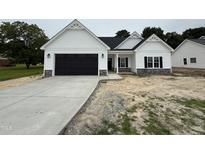Charming one-story home with a black garage door and a concrete driveway and stone accents at 1008 Peedin Rd, Selma, NC 27576