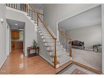 Spacious foyer features hardwood floors, staircase, and opens into the living room and kitchen at 112 Natchez Ct, Cary, NC 27519