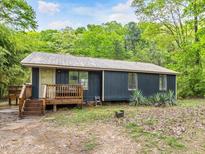 Cozy one-story home featuring a small front porch and surrounded by lush greenery at 1204 Hydrangea Ct, Hillsborough, NC 27278