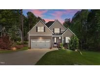 Charming two-story home with a well-manicured lawn and attached two-car garage at 128 Waterleaf Pl, Clayton, NC 27527