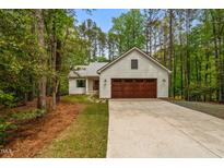 Charming craftsman home with a pristine driveway, a two-car garage, and an idyllic wooded lot at 1368 Ohio Ln, Sanford, NC 27332