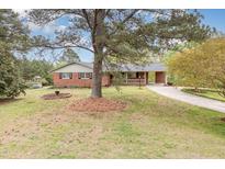 Charming brick home with a spacious front yard, mature trees, and a welcoming driveway at 1750 Spring Valley Lake Rd, Henderson, NC 27537