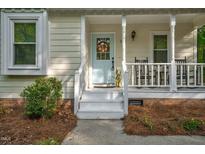 Charming home featuring a light blue front door with a decorative wreath and a welcoming porch at 2108 Canterbury Rd, Clayton, NC 27520