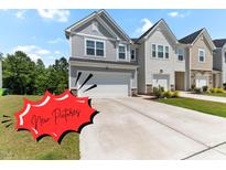 Charming two-story home with a two-car garage and a well-maintained lawn on a bright, sunny day at 2137 Caen St, Raleigh, NC 27610