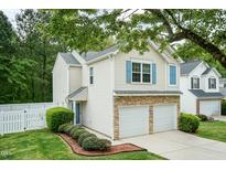 Charming two-story home with a two-car garage and manicured front lawn and tasteful stone accents at 228 Adefield Ln, Holly Springs, NC 27540