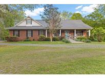 Charming brick home with a welcoming front porch and well-maintained landscaping at 2456 Nealwood Ave, Graham, NC 27253