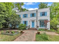 Charming two-story home with a white brick facade, blue shutters, and a well-manicured front yard at 2625 Dover Rd, Raleigh, NC 27608