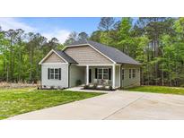 Charming single-story home with a well-manicured lawn, cozy front porch and extended driveway at 318 Natchez Trace, Fuquay Varina, NC 27526