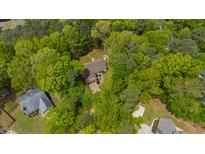 An aerial view of a quaint home nestled within lush, mature trees at 3428 Hardwood Dr, Apex, NC 27539