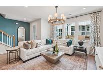 Bright living room with modern lighting, neutral colors, and stylish furnishings, creating an inviting space at 605 Callan View Ave, Wake Forest, NC 27587