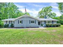 Charming single-story home featuring a well-manicured lawn, a gray brick facade and inviting curb appeal at 612 E Academy St, Fuquay Varina, NC 27526