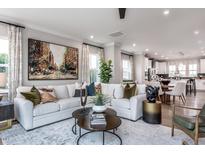 Bright living room featuring a large sectional sofa, contemporary decor, and hardwood floors at 801 Hyperion Aly, Wake Forest, NC 27587
