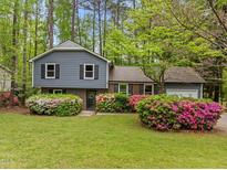 Charming two-story home with beautiful landscaping featuring colorful azaleas and a well-maintained lawn at 1005 Winwood Dr, Cary, NC 27511