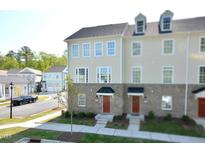 Beautiful three-story townhome featuring a brick and siding exterior with large windows at 1020 Kentlands Dr, Durham, NC 27713