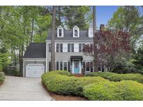 Charming two-story home with a light gray exterior, blue door, dormer windows, and lush landscaping at 117 Vicksburg Dr, Cary, NC 27513