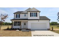 Charming two-story home with white siding, black trim, and an attached two-car garage at 120 W Saltgrass Ln, Smithfield, NC 27577