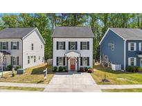 Charming two-story home with white siding, black shutters, a red front door, and a well-manicured front lawn at 166 Yellow Jacket Rdg, Clayton, NC 27520