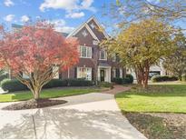 Charming brick home with manicured lawn and mature trees under a bright sky at 204 Oxford Mill Ct, Cary, NC 27518