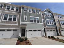 Townhome exterior featuring a white garage door, neutral siding and a black front door at 2313 Bay Minette Sta # 543, Apex, NC 27502