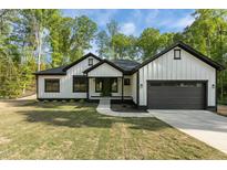 Charming modern farmhouse with white siding, black trim, and a well-manicured lawn at 251 Sequoia Dr, Louisburg, NC 27549