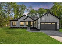 Charming single-Gathering home boasts a modern farmhouse style, complemented by a well-manicured lawn and beautiful twilight at 251 Sequoia Dr, Louisburg, NC 27549