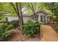 Charming exterior view of a well-maintained home featuring a wooden walkway and lush landscaping around the house at 2852 Rue Sans Famille, Raleigh, NC 27607