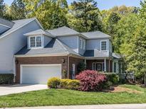 Charming two-story home with a well-manicured lawn, attached garage, brick accents, and mature trees at 3608 Burwell Rollins Cir, Raleigh, NC 27612