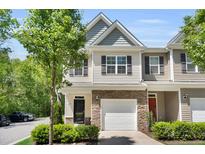 Inviting two-story townhouse with stone accents, attached garage, tidy landscaping, and charming curb appeal at 3667 Durwood Ln, Raleigh, NC 27604