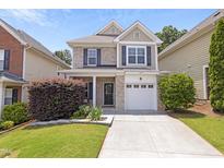 Charming two-story home featuring a brick facade, a well-manicured lawn, and an attached garage at 3811 Yates Mill Trail, Raleigh, NC 27606