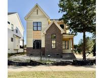 New construction two-story home featuring brick and siding exterior with large windows and a welcoming entryway at 3817 Coach Lantern Ave, Wake Forest, NC 27587