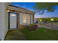 Inviting front entrance with brick and well maintained lawn and mature landscaping at 42 Riverwalk Ter, Durham, NC 27704