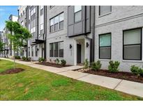 Modern townhome with gray brick, black window frames, and manicured landscaping at 433 Wait Ave # 100, Wake Forest, NC 27587