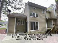 Two-story home features a neutral color scheme, ample windows, a covered patio, and mature trees at 4420 Beechnut Ln, Durham, NC 27707