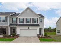 Inviting two-story townhome with a two-car garage and a well-maintained front yard in a suburban neighborhood at 5016 Tura St, Raleigh, NC 27610