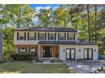 Charming two-story home featuring a brick and siding exterior, complemented by a well-manicured front yard and mature trees at 5315 Oakbrook Dr, Durham, NC 27713