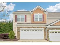 Charming townhome featuring a stone facade and two-car garage under a bright blue sky at 617 Sealine Dr, Cary, NC 27519