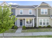 Charming townhouse with a welcoming front porch and rocking chairs, complemented by well-manicured landscaping at 6511 Academic Ave, Raleigh, NC 27616