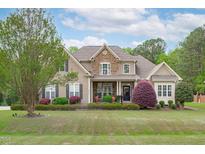 Inviting two-story home features a mix of stone and siding with a beautifully landscaped front yard at 6512 Southern Times Dr, Raleigh, NC 27603