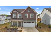 Charming two-story home featuring a 2-car garage and meticulously maintained landscaping at 7205 Tillage Rd, Mebane, NC 27302