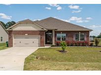Charming brick home featuring manicured landscaping and a convenient two-car garage at 8 Pal Ct, Benson, NC 27504