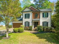 Charming two-story home with a well-manicured lawn and inviting curb appeal nestled in a tree filled landscape at 8100 Knebworth Ct, Raleigh, NC 27613