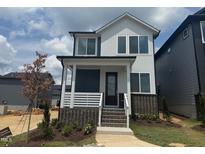 Charming two-story home showcasing a brick foundation, covered porch, and modern architectural design at 10 Relaxing Way, Pittsboro, NC 27312