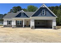 Charming home featuring stone accents and a covered front porch, plus an attached two-car garage at 1000 Peedin Rd, Selma, NC 27576